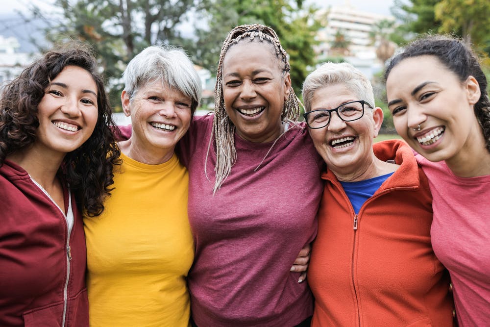 A group of women hugging each other, smiling and having a good time