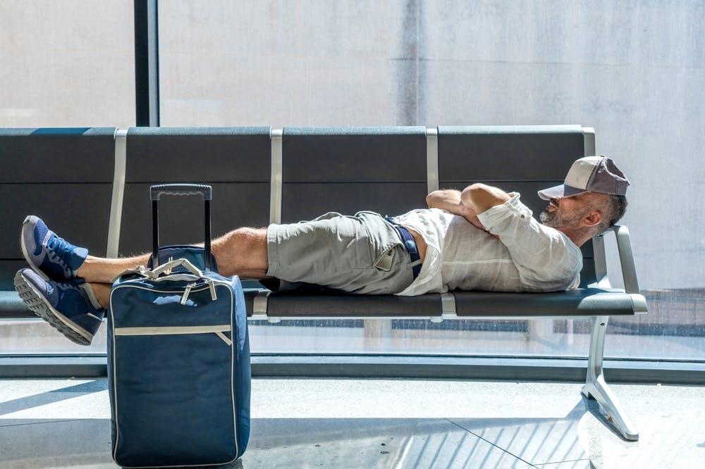 Man sleeping at an airport to avoid jet lag