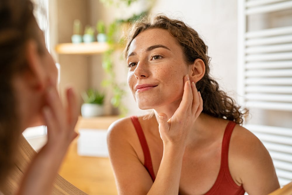 Woman applying Duac Once Daily Gel to her face