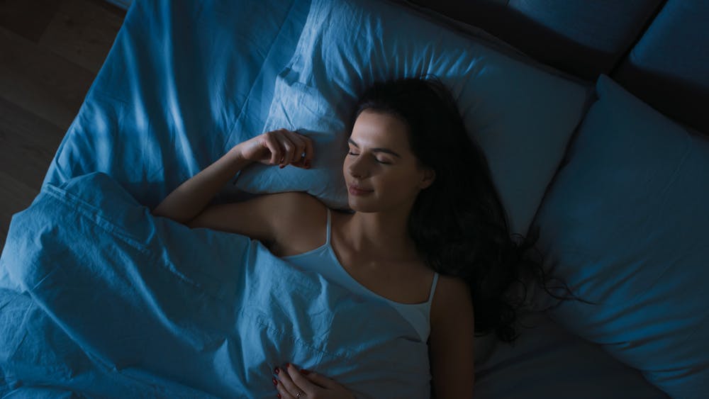 Lady sleeping in bed knowing the benefits of sleep for weight loss